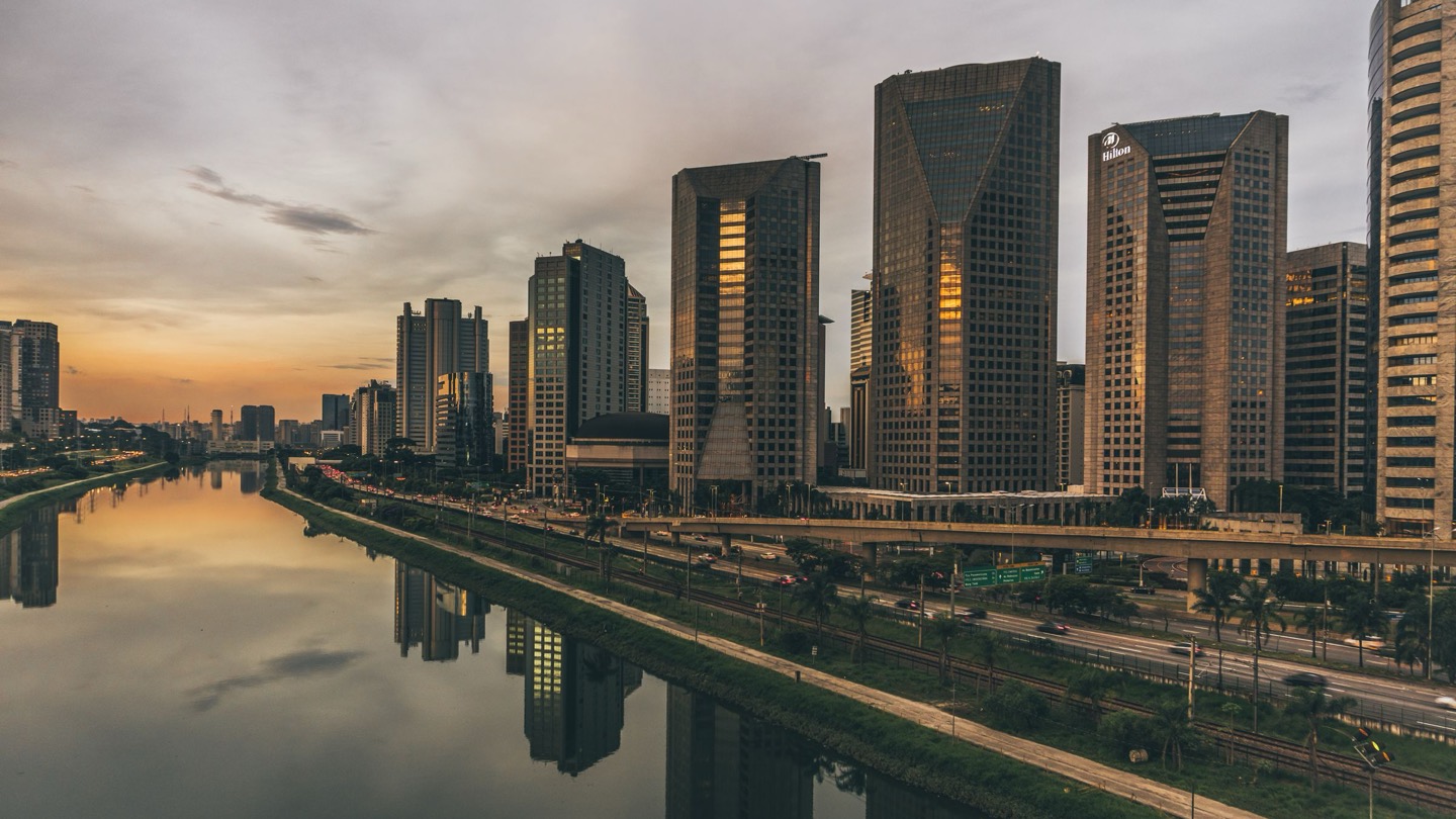 Torres de escritórios da Avenida das Nações Unidas refletidas no Rio Pinheiros ao pôr do sol, em São Paulo
